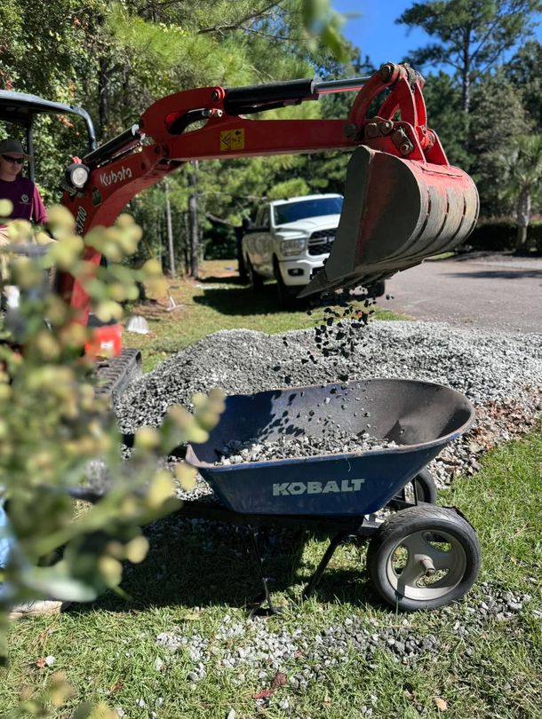 machine filling wheelbarrow with rocks